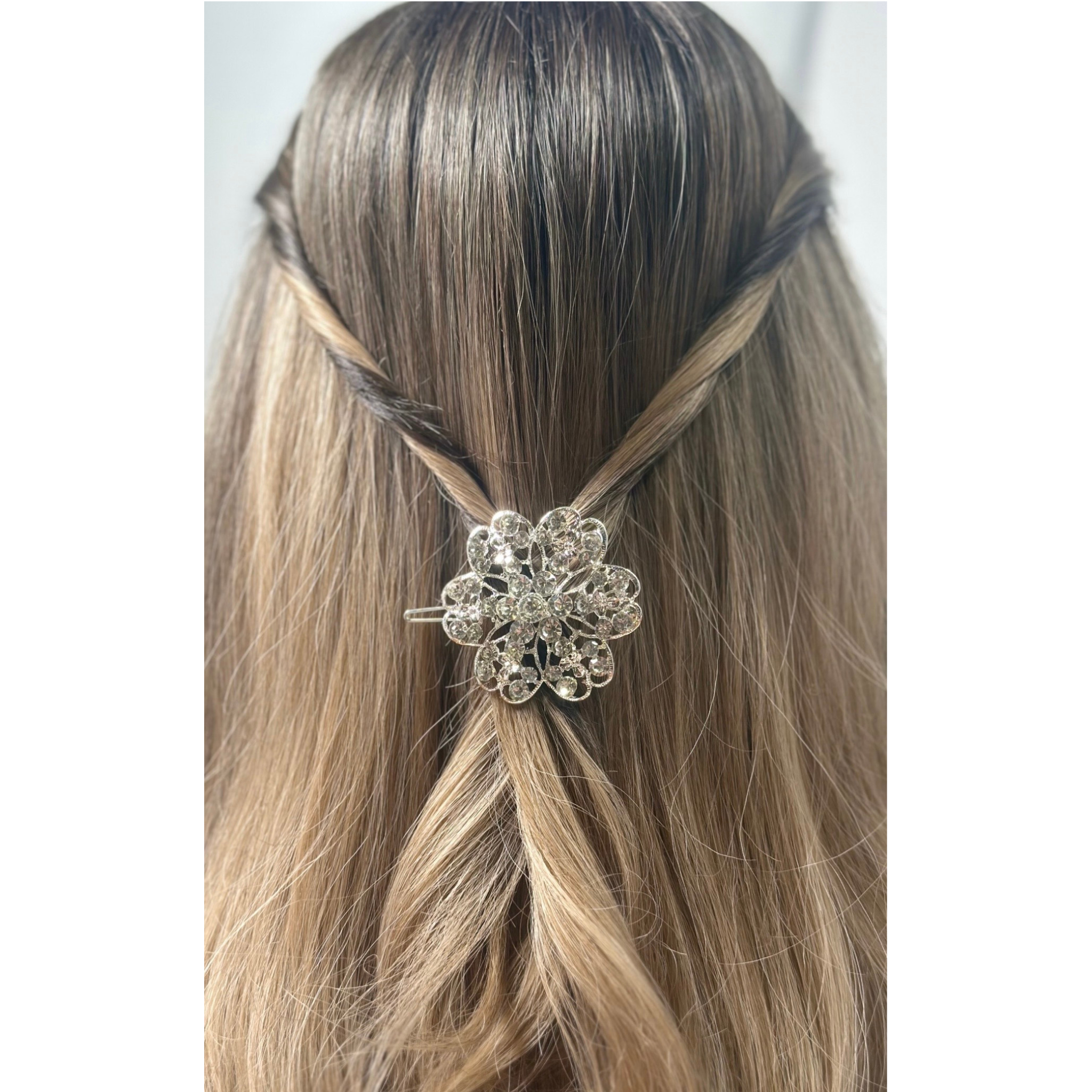 Hair accessory with a decorative flower design on a mannequin head with brown hair.