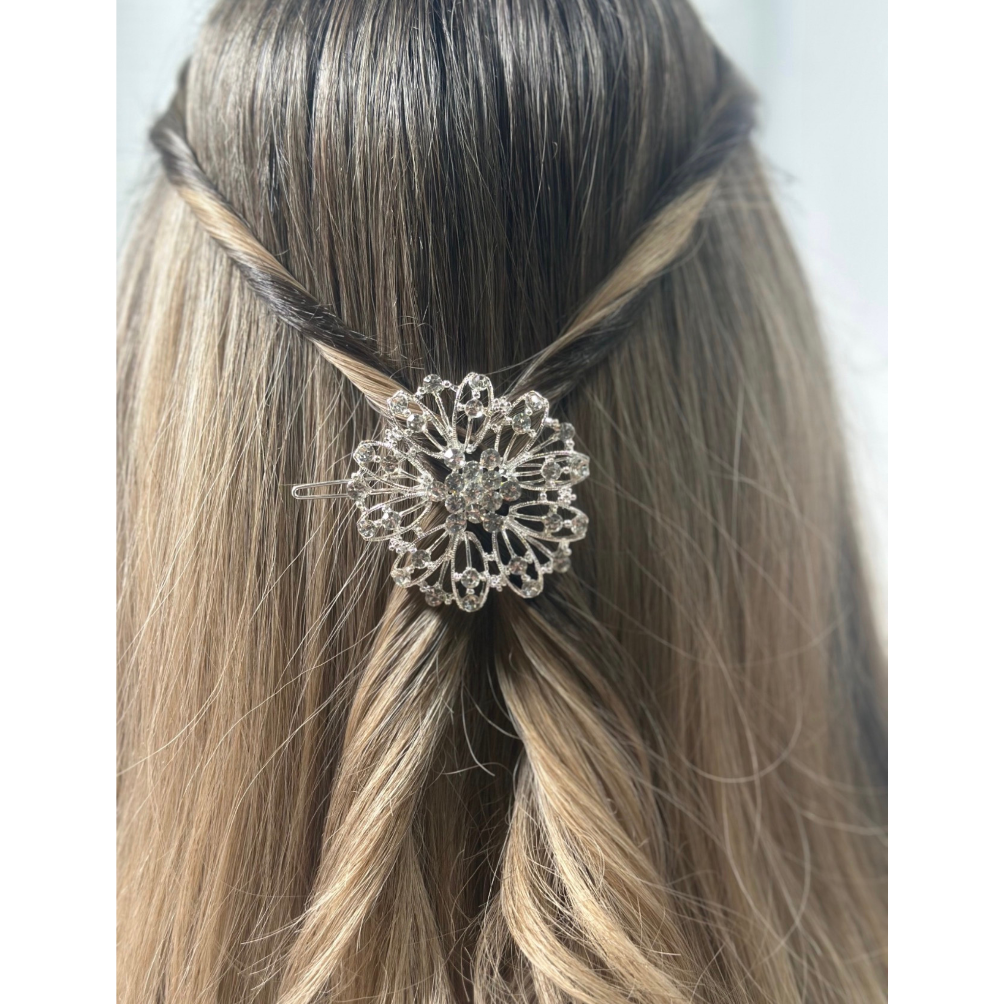 Silver hair accessory on a person's head with a plain background