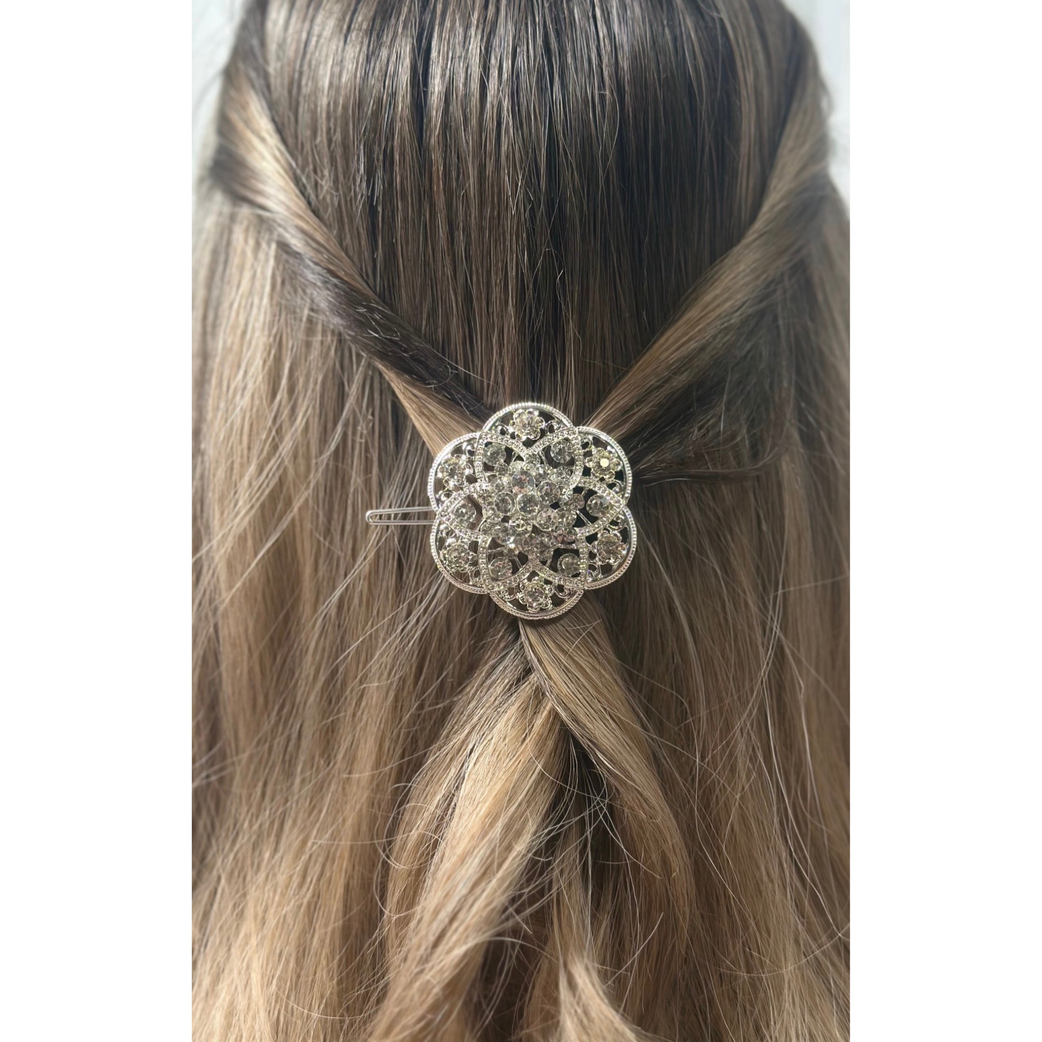 Decorative hair clip in a person's hair on a white background