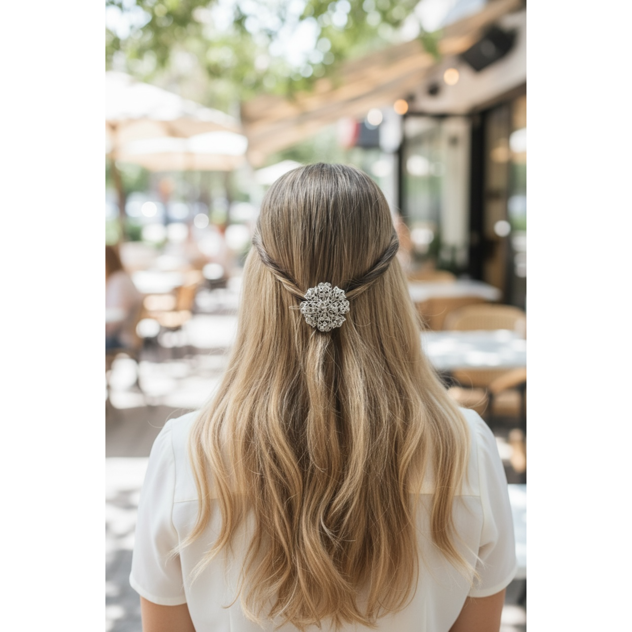 Person with long blonde hair wearing a decorative hairpin outdoors.