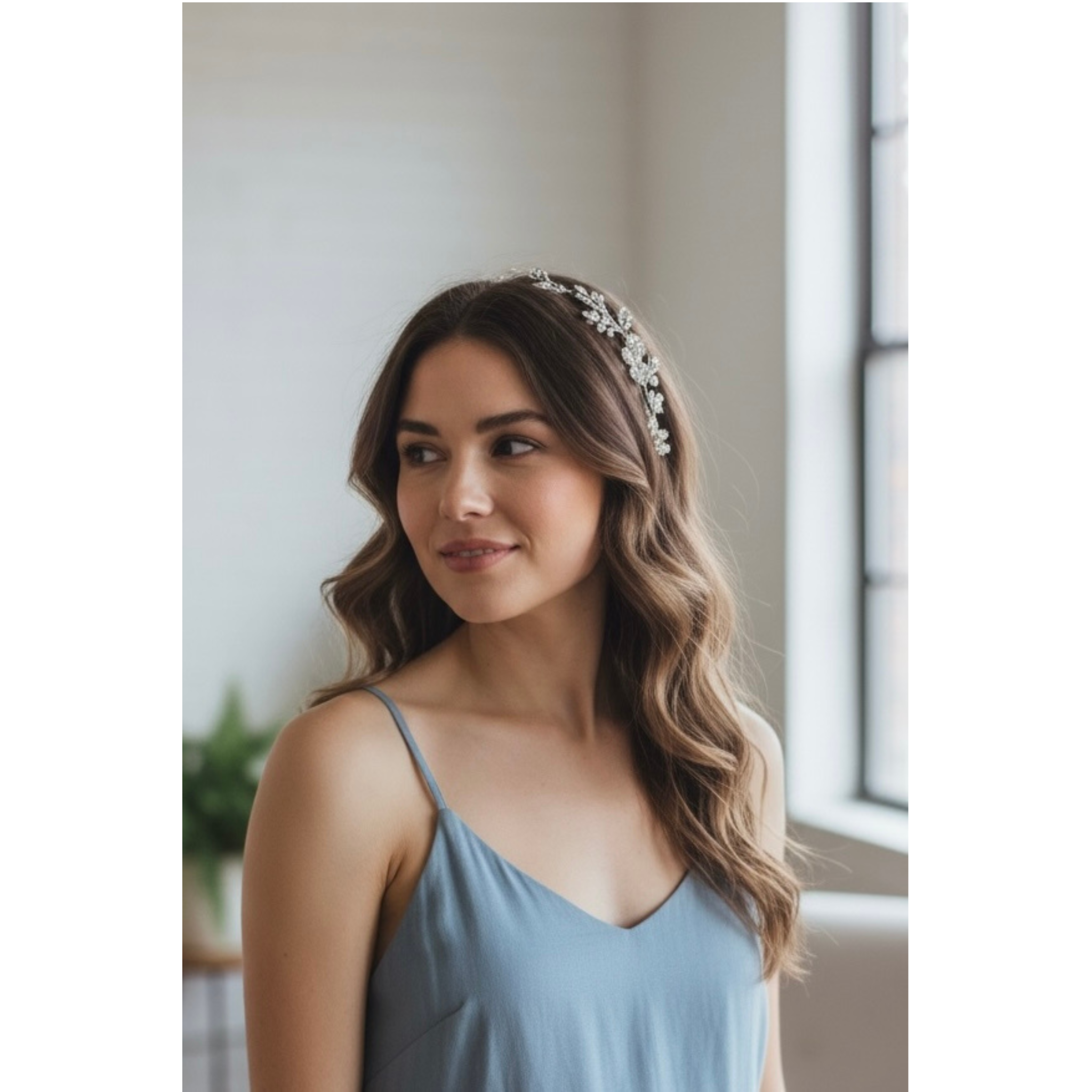 Woman wearing a light blue dress with a decorative headband indoors.