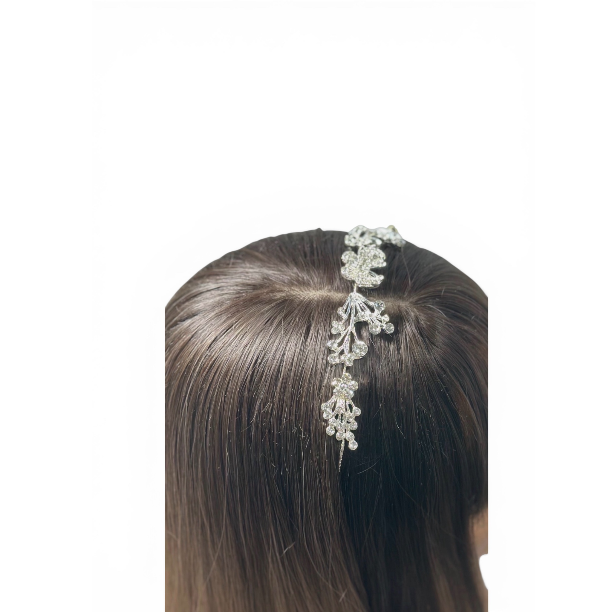 Silver headband on a person's head with a plain background