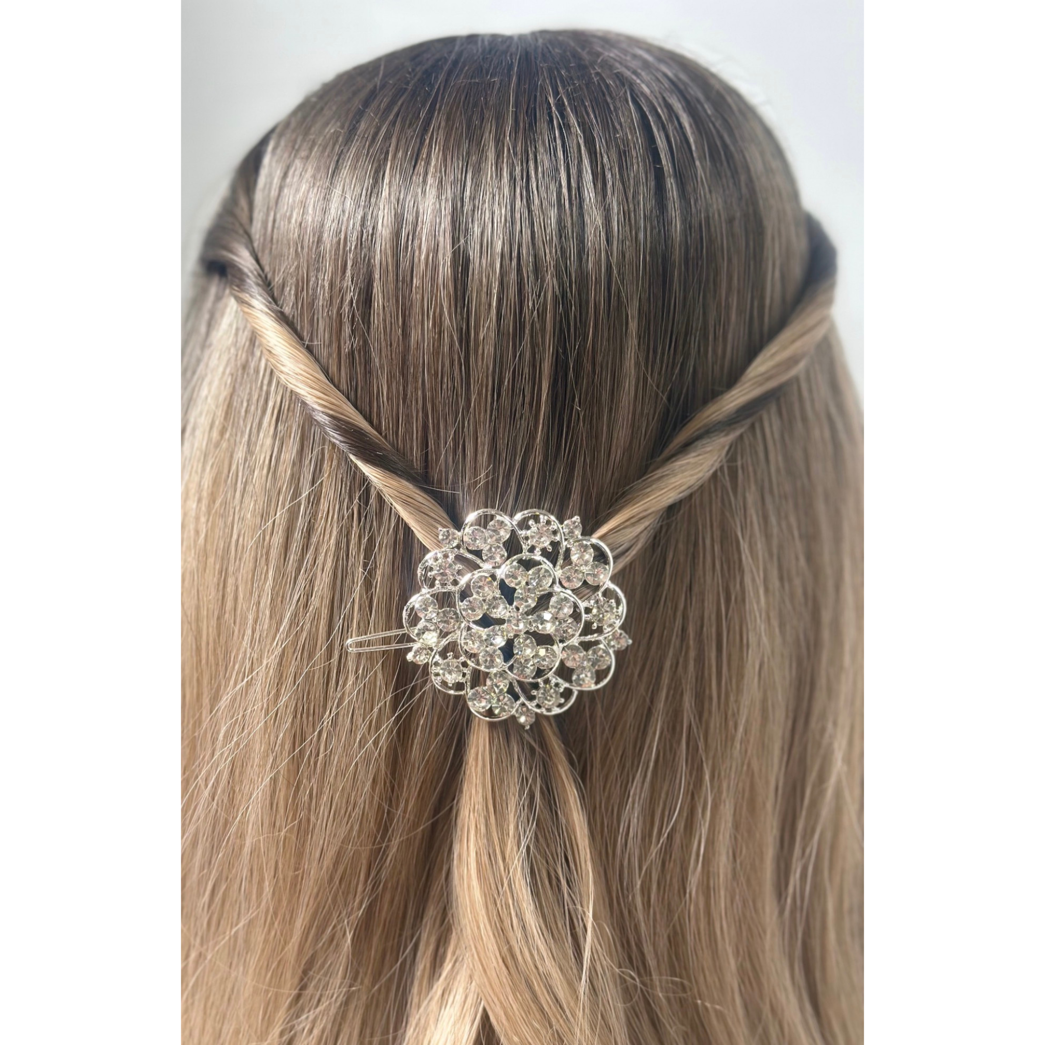 Hair accessory with decorative element on a mannequin head against a white background