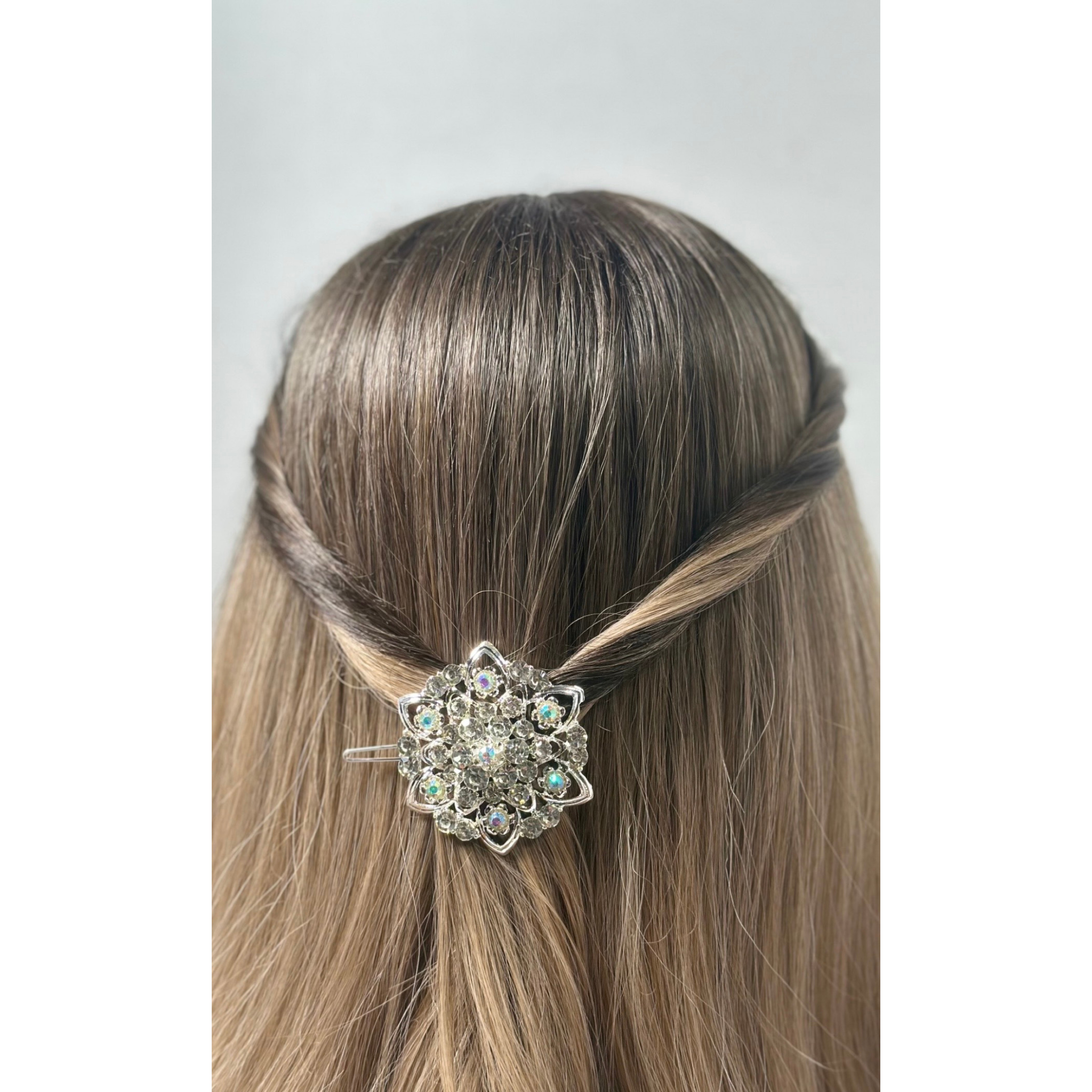 Hair accessory with crystals on a mannequin head against a plain background