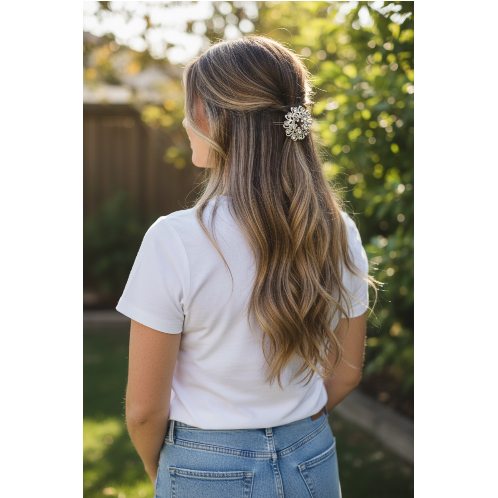Person with long hair wearing a white shirt and blue jeans, standing outdoors. The highlight of this image is the decorative multicolor hairclip that is styled on the women's hair.