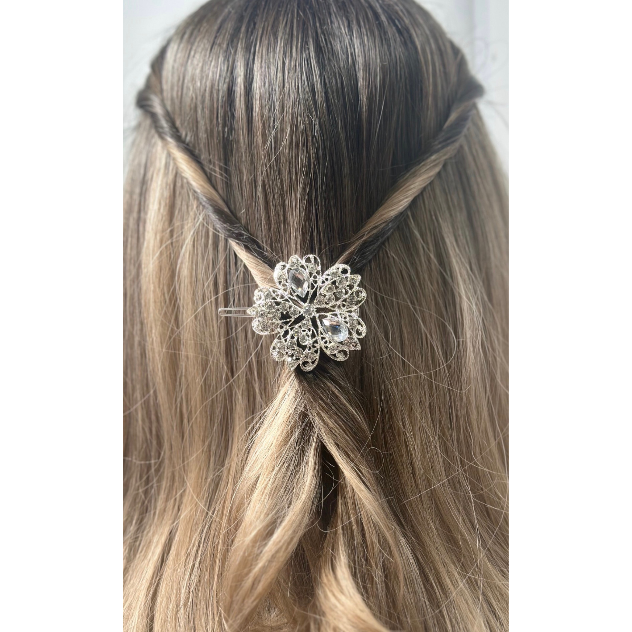 Decorative multicolor hair accessory worn by a woman with braided hair on a white background