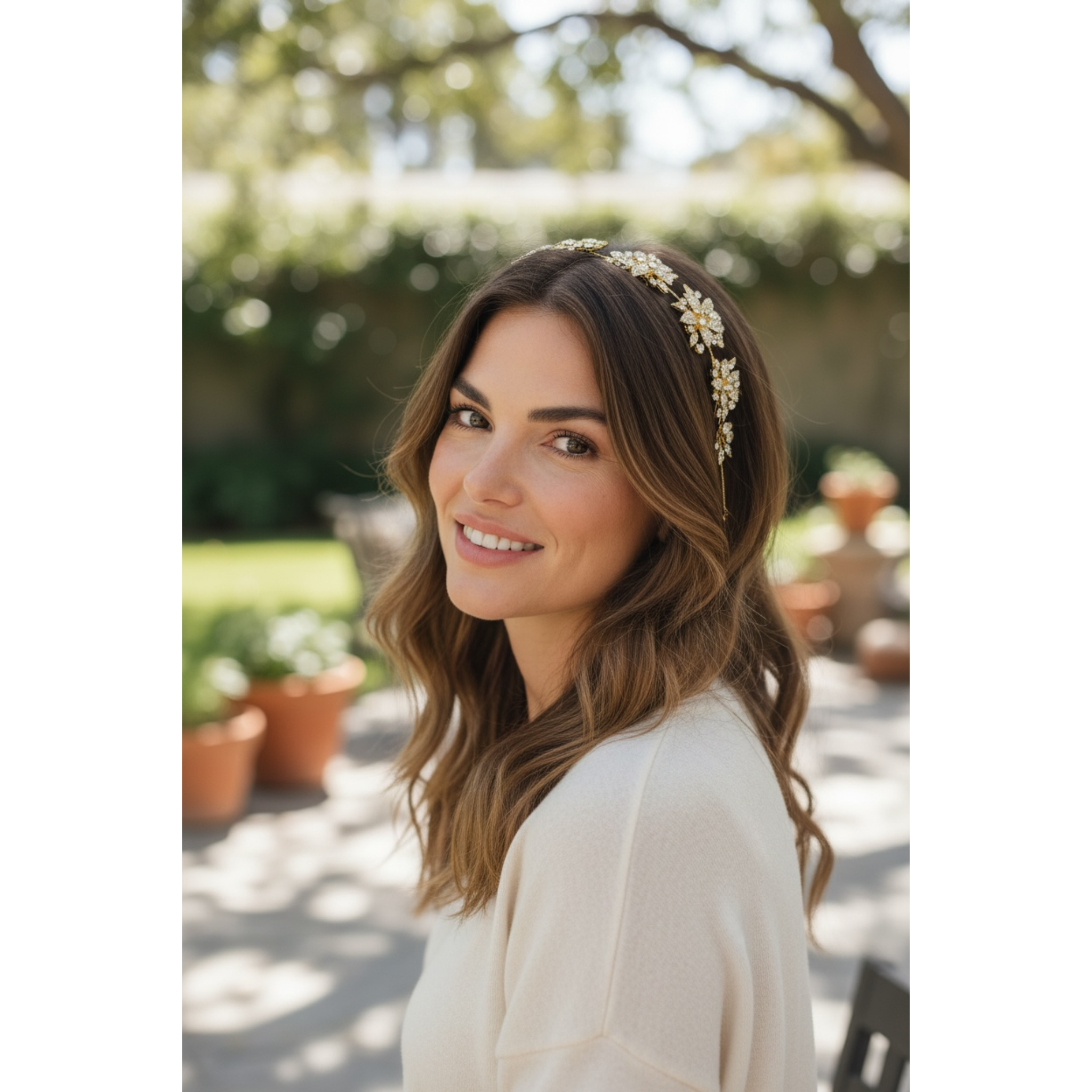 Woman wearing a floral headband outdoors with greenery in the background