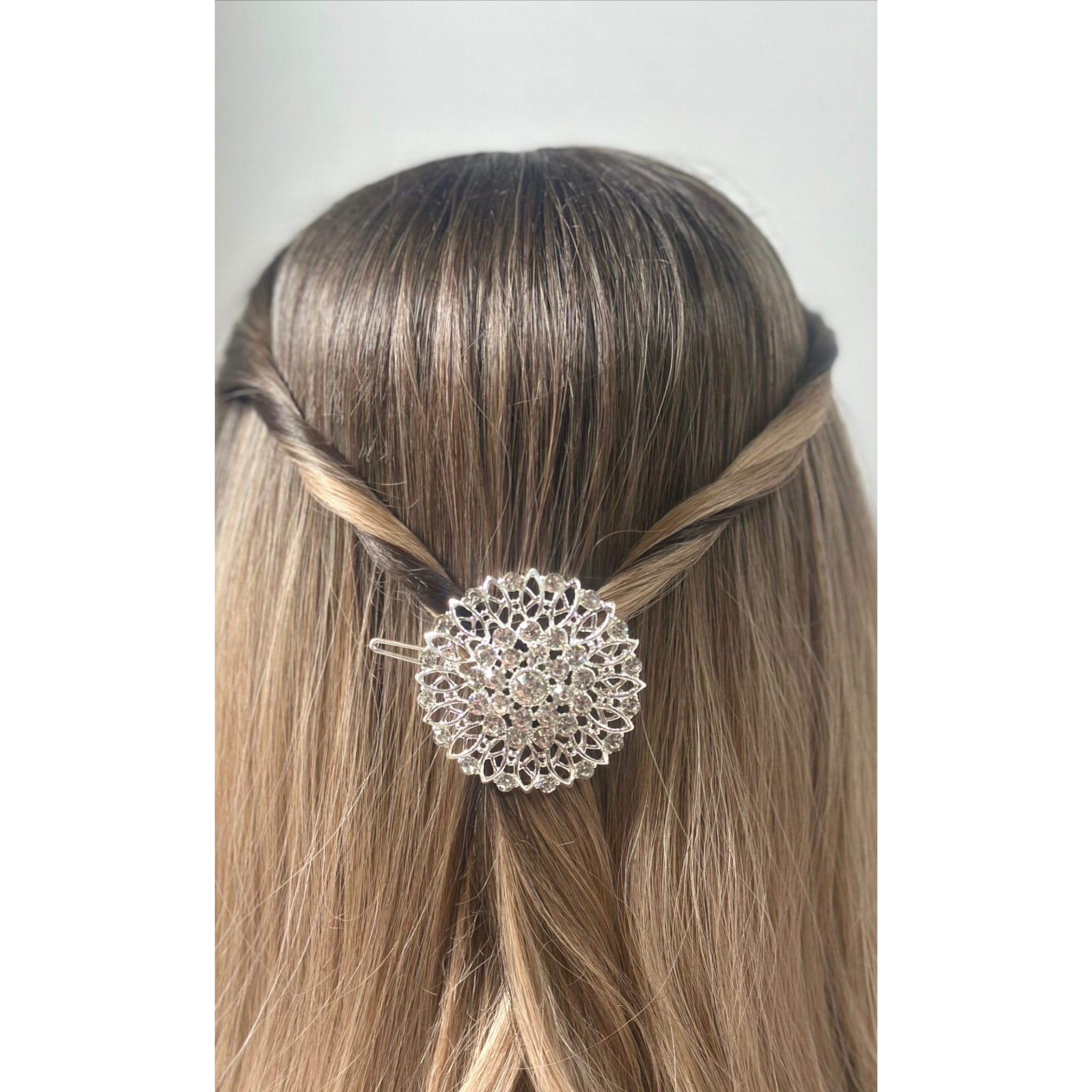 Hair accessory with a decorative element on a person's head against a neutral background