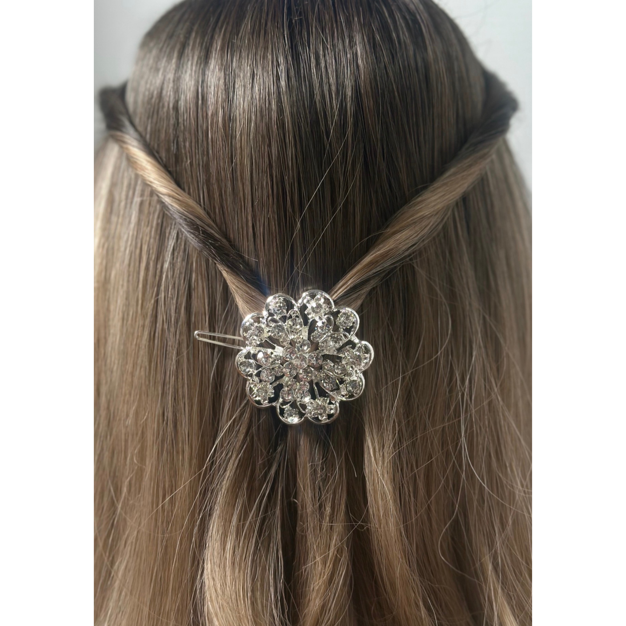 Silver floral hair clip on a mannequin head with brown hair.