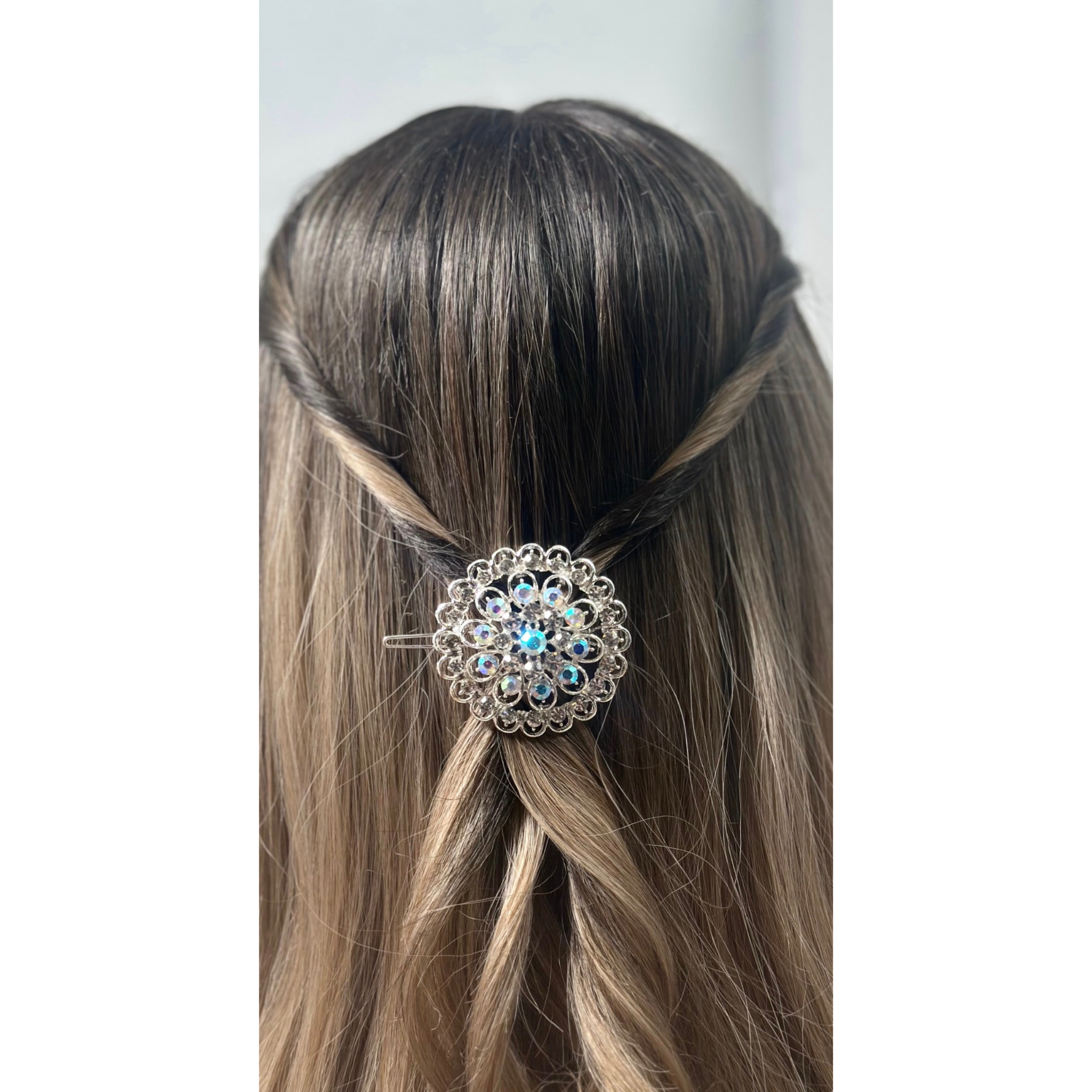 Hair accessory with decorative element in a person's hair against a neutral background