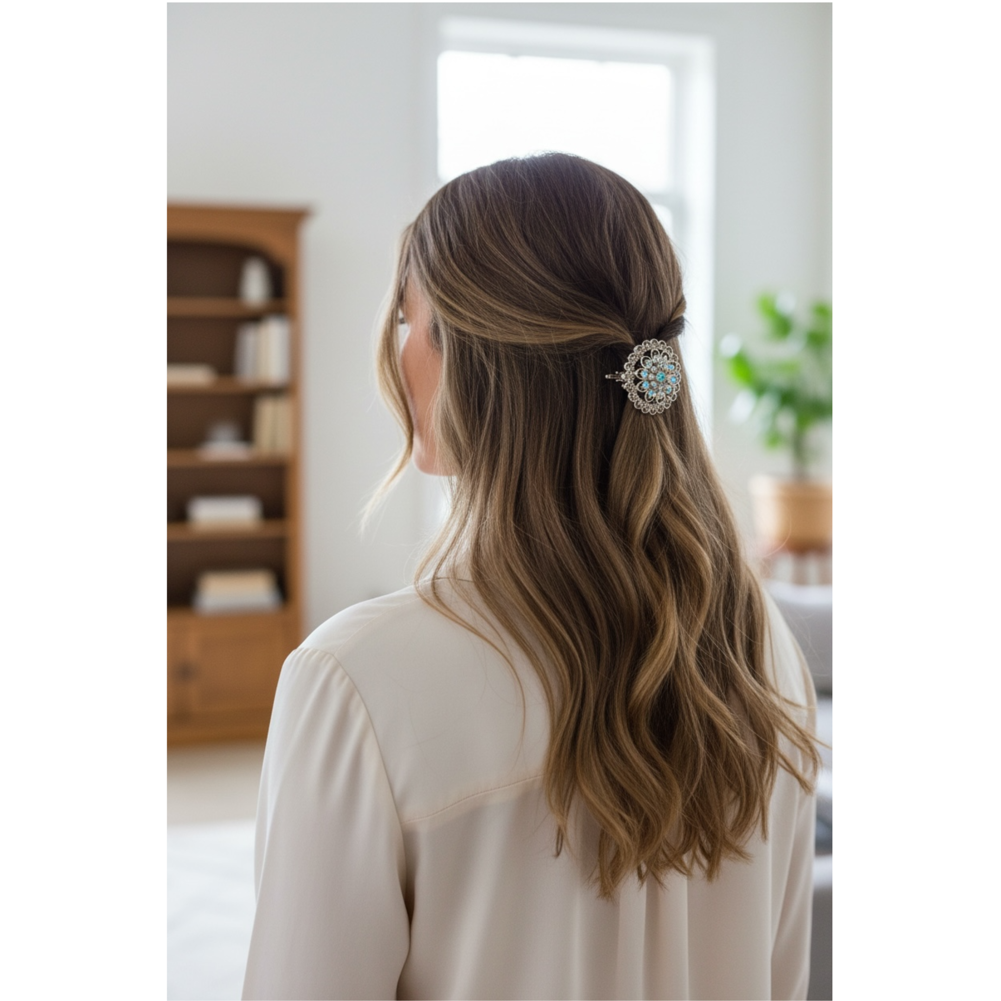 Woman with long, wavy hair wearing a decorative hair clip indoors.