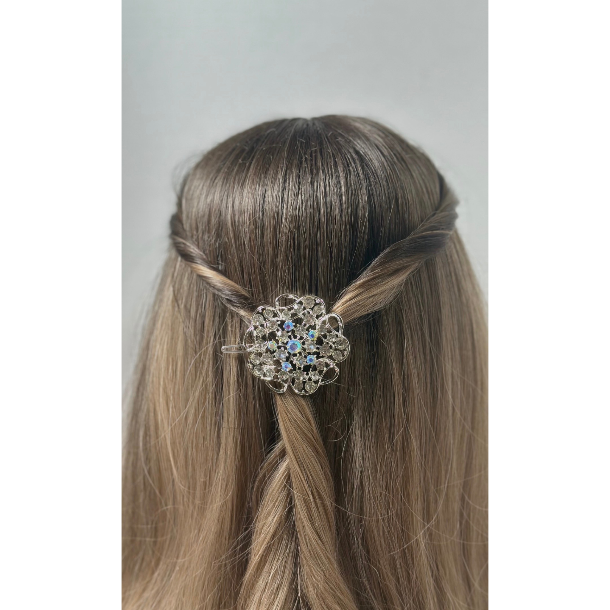 Hair accessory with decorative element in a styled hair on a plain background