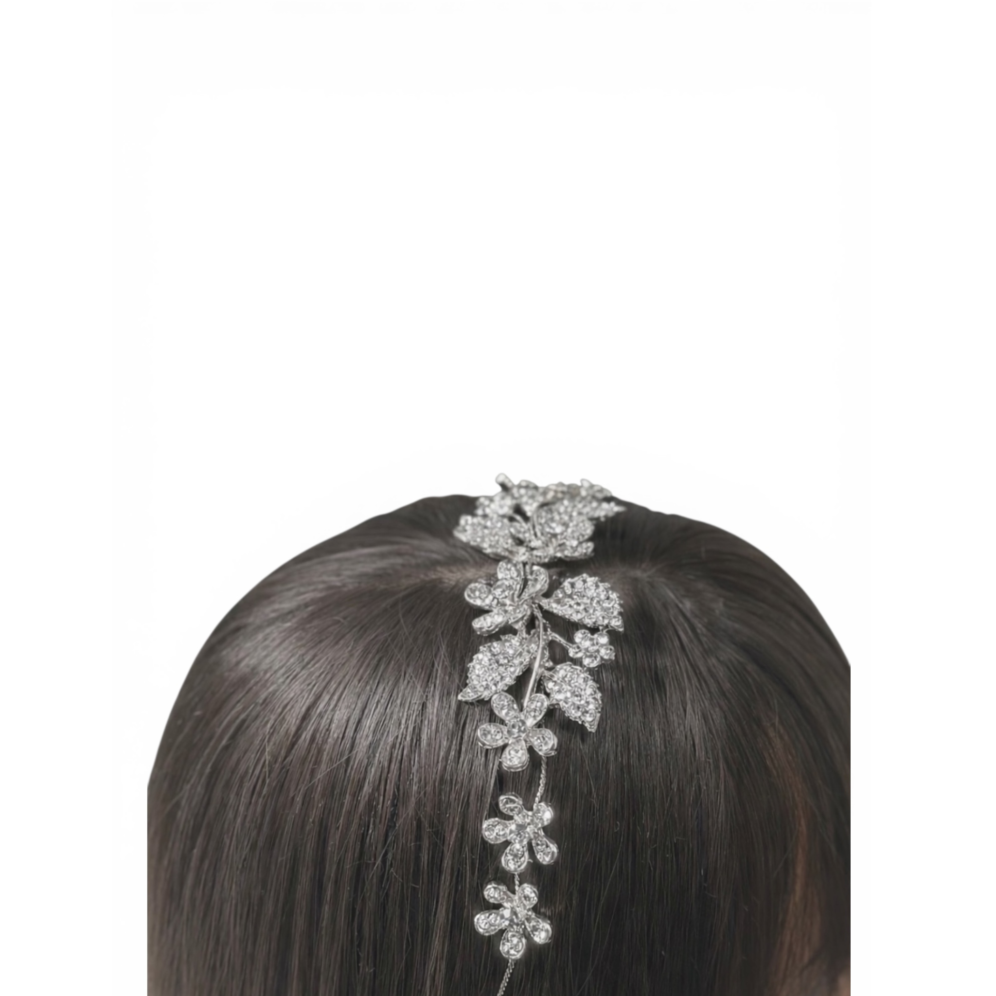 Silver floral shaped headband accessory on a woman's head with dark hair against a white background