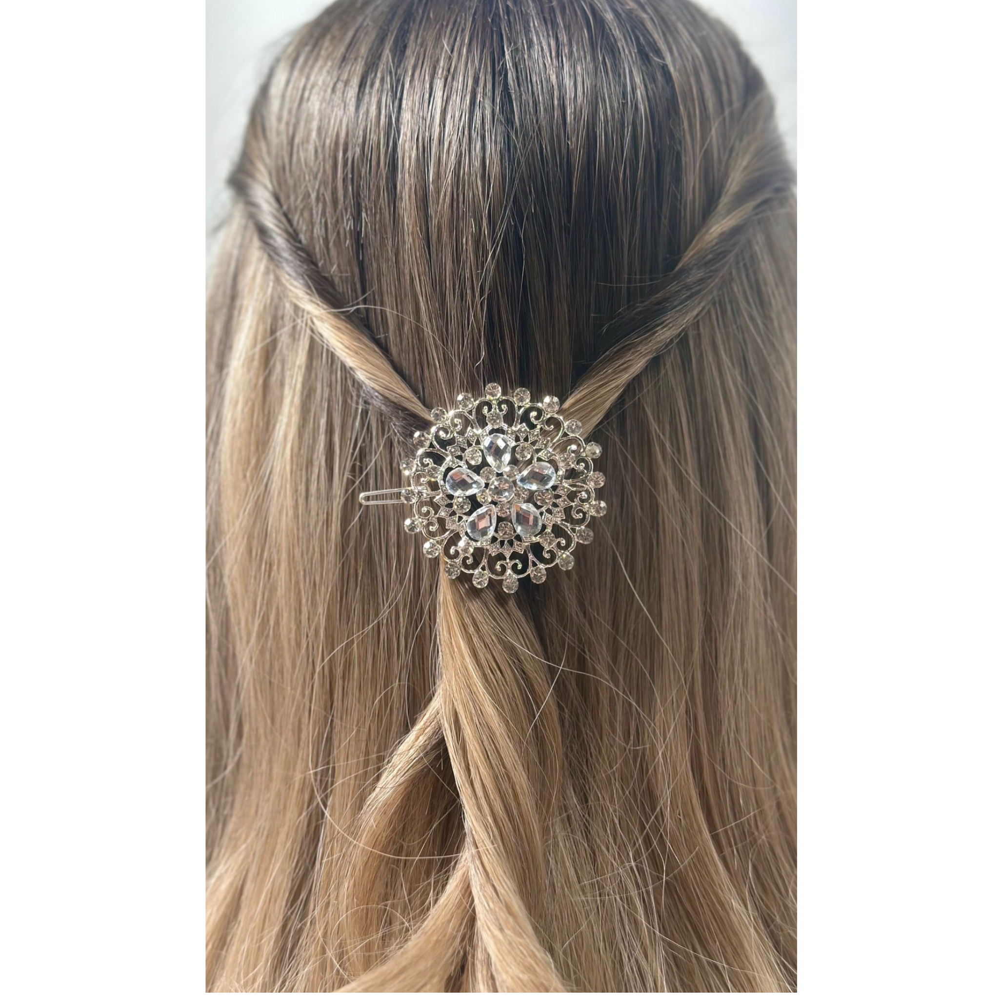 Elegant hair accessory with crystals in a person's hair on a white background