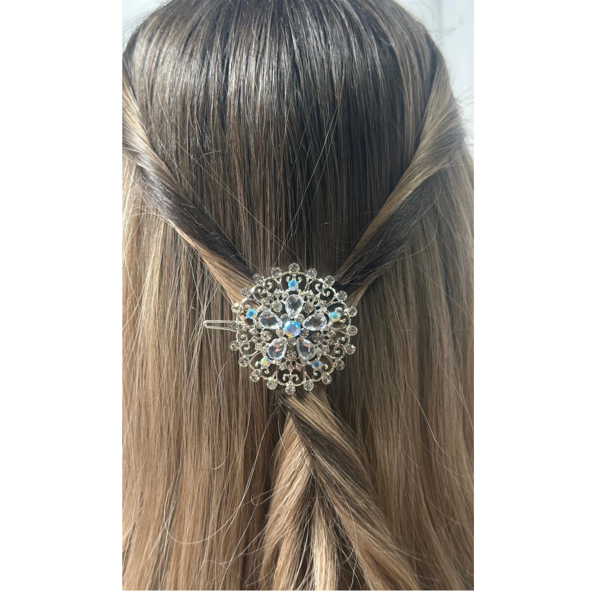 Decorative hair clip with crystals in a person's braided hair on a white background