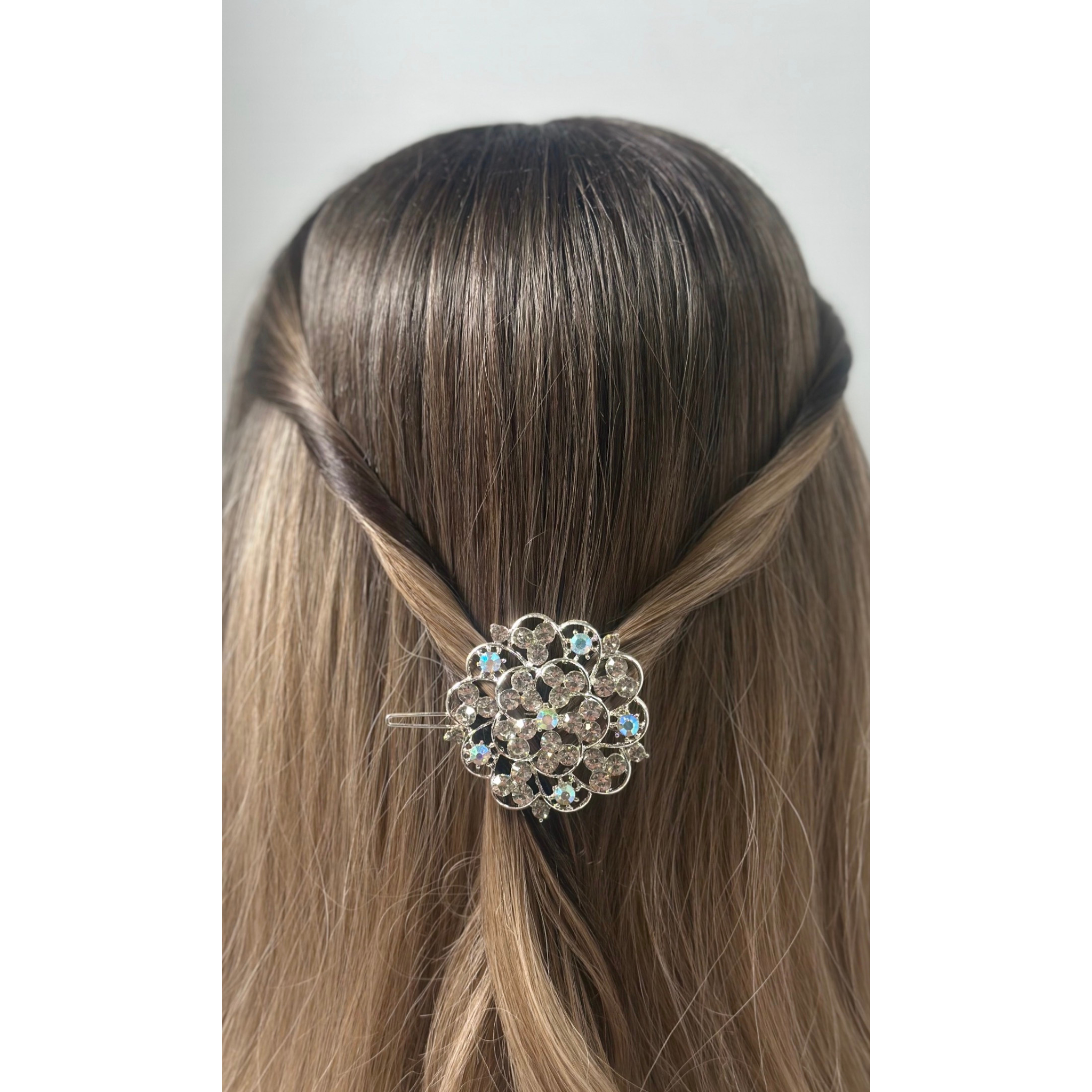 Decorative hair clip in a person's hair against a plain background
