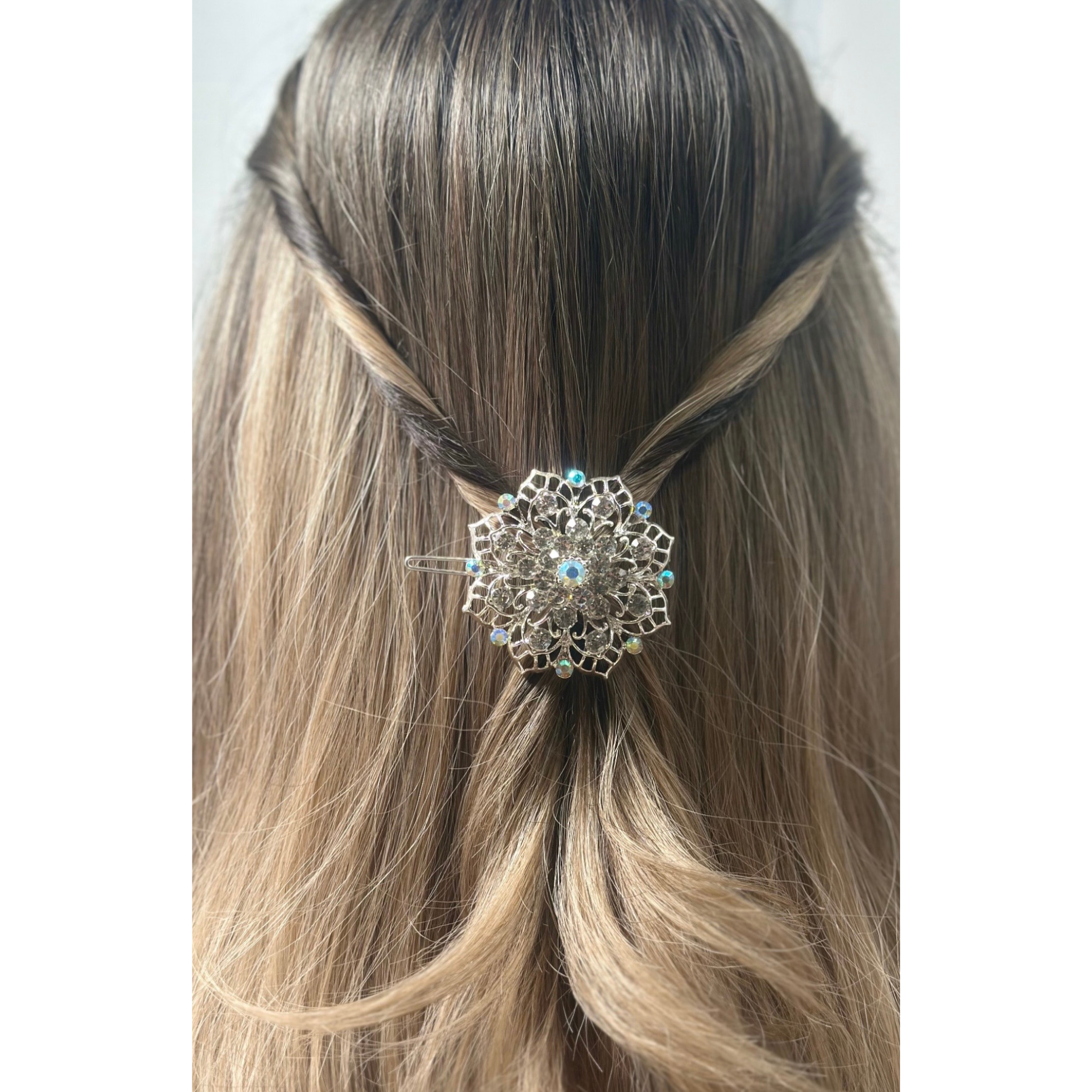 Decorative hair clip in a person's hair on a plain background