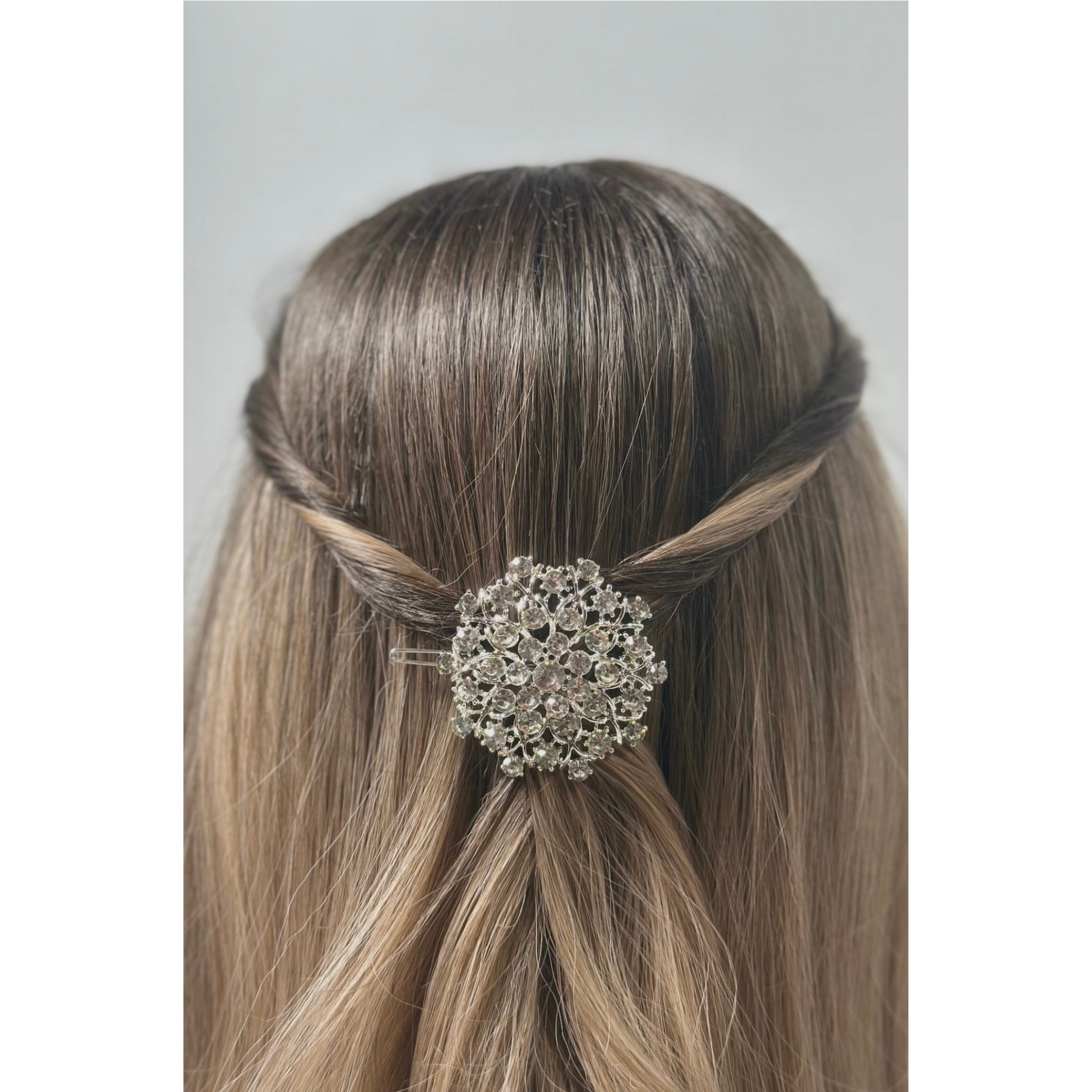 Hair bun with a decorative hair clip on a plain background