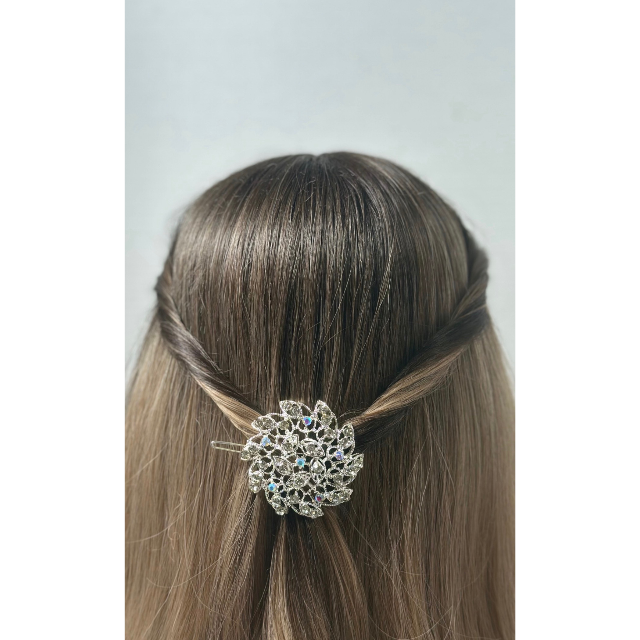 Hair accessory with decorative element on a person's head against a neutral background