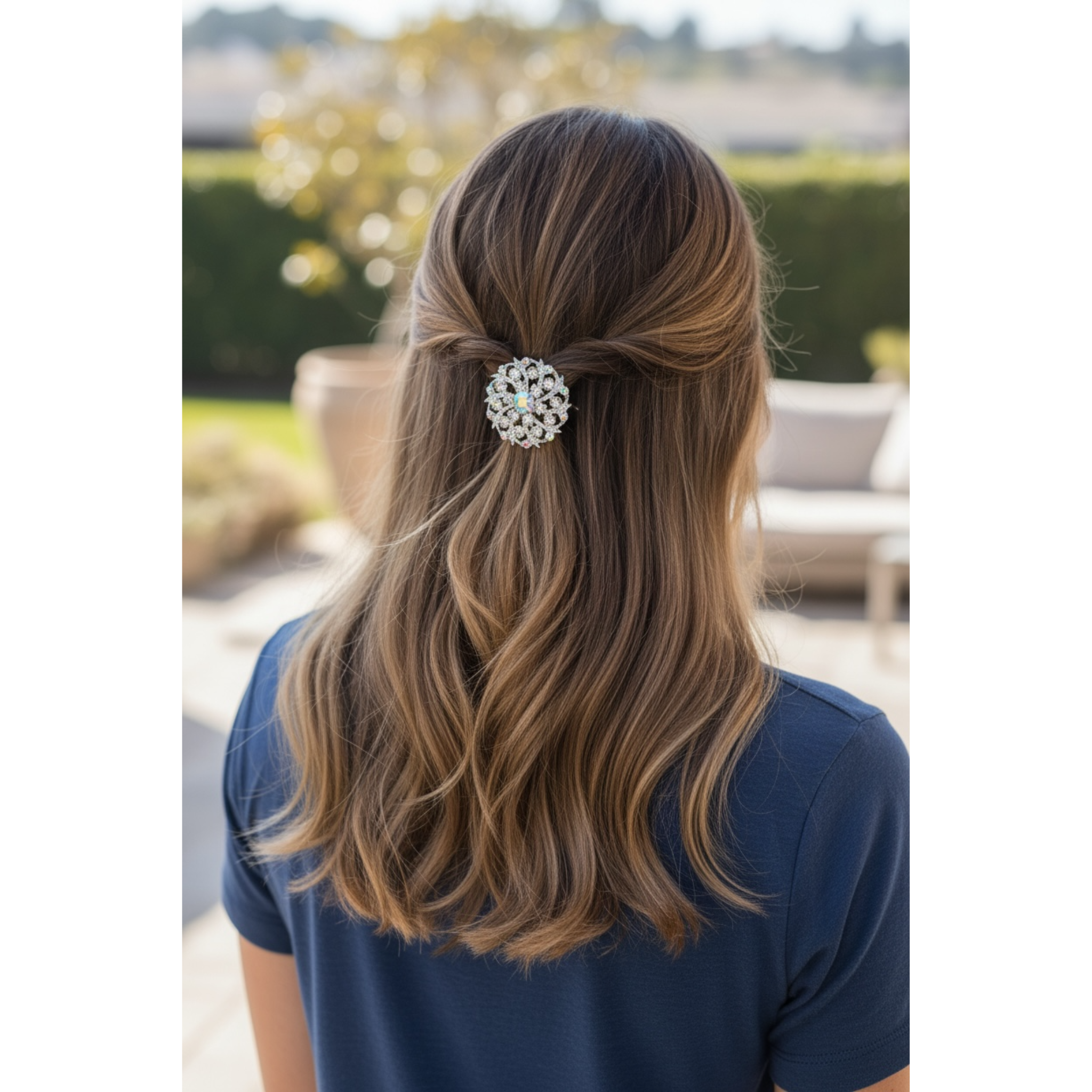 Person with long, wavy hair wearing a decorative hair clip outdoors.