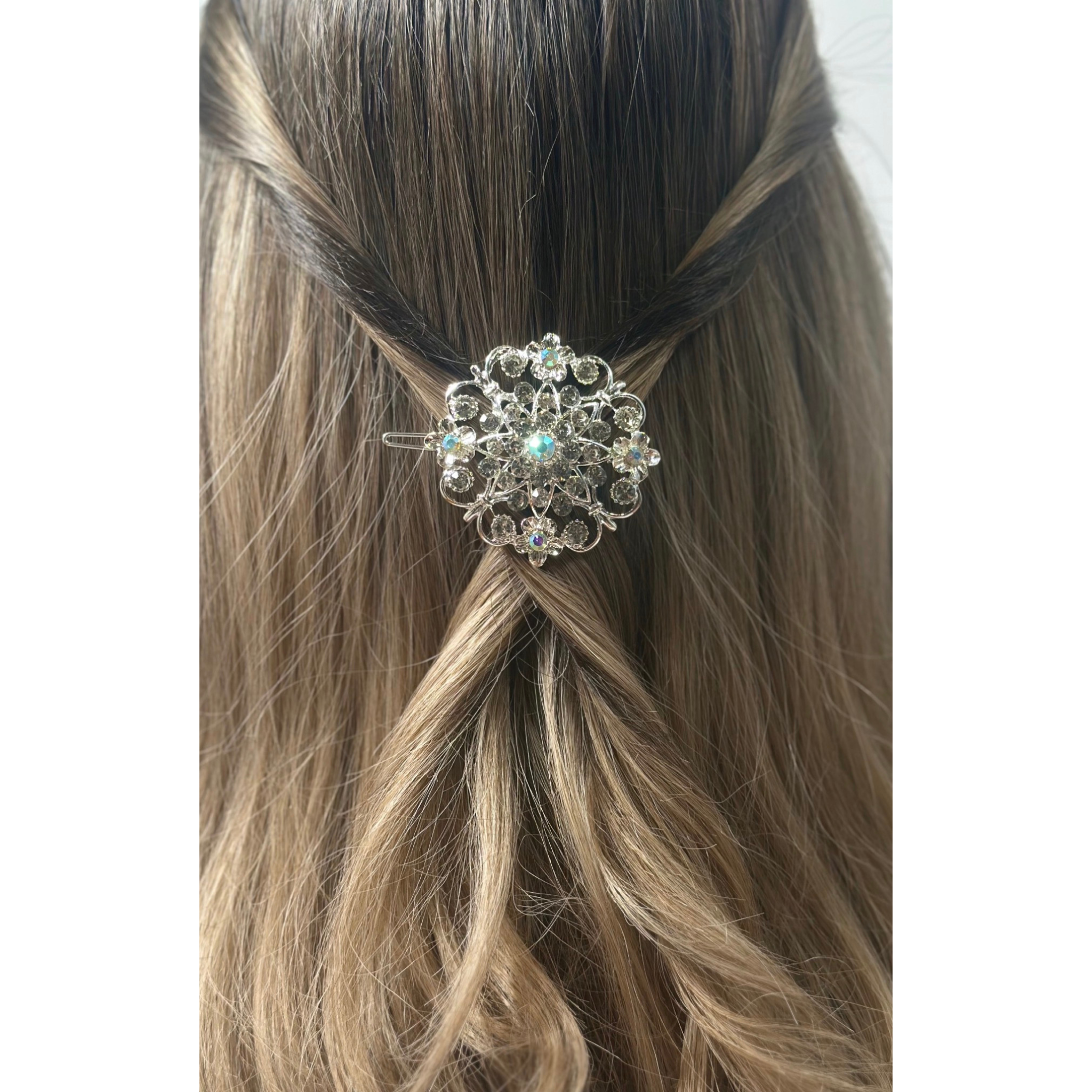Decorative hair clip on a person's hair with a plain background