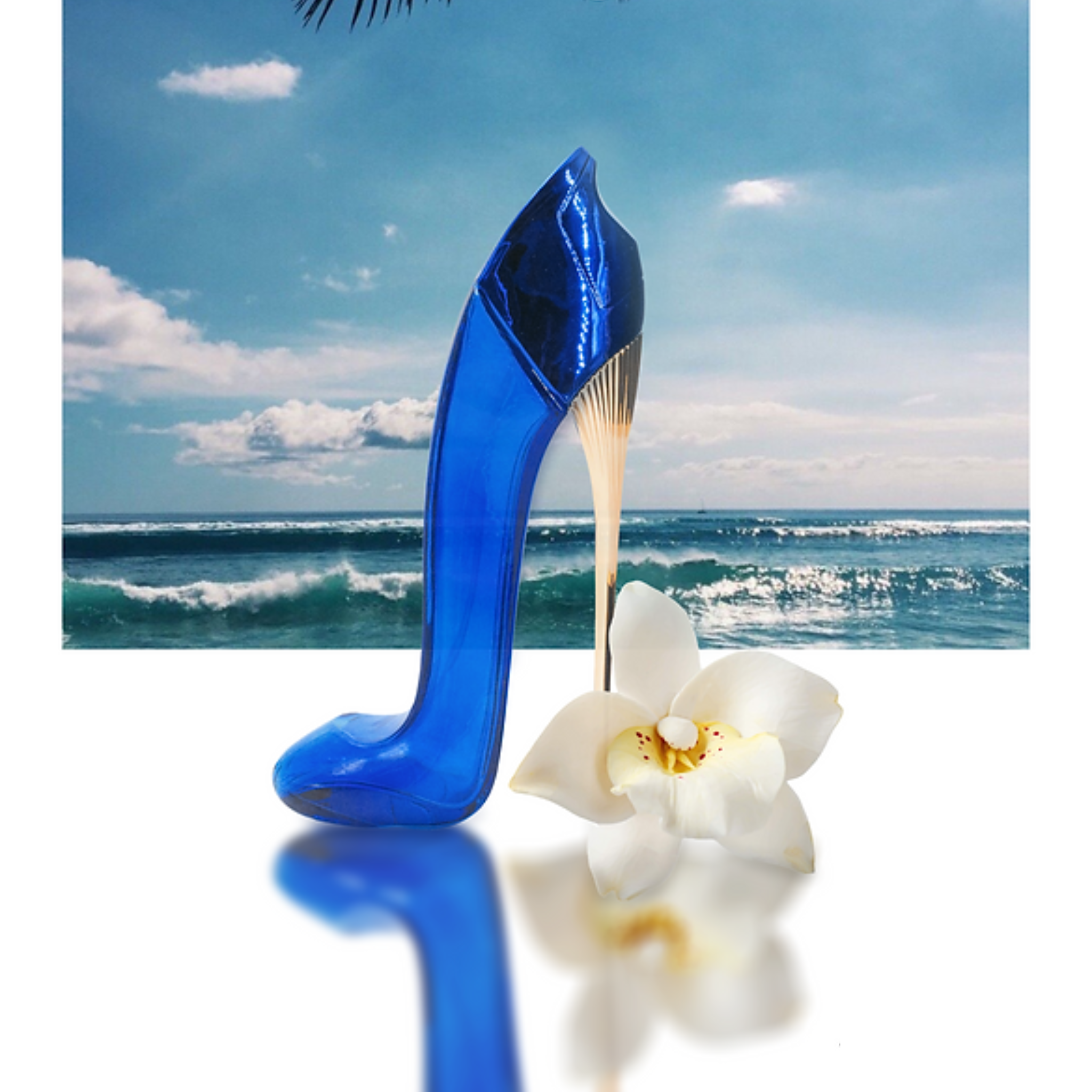 Blue high-heeled shoe with a white flower against a beach background. This fragrance is from EBC Collection.