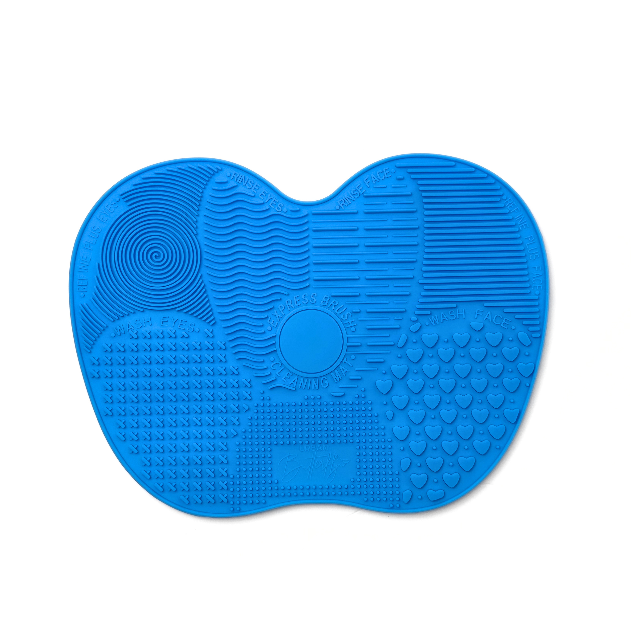 She makeup Brand Blue silicone brush cleaning mat with textured surface on a white background.